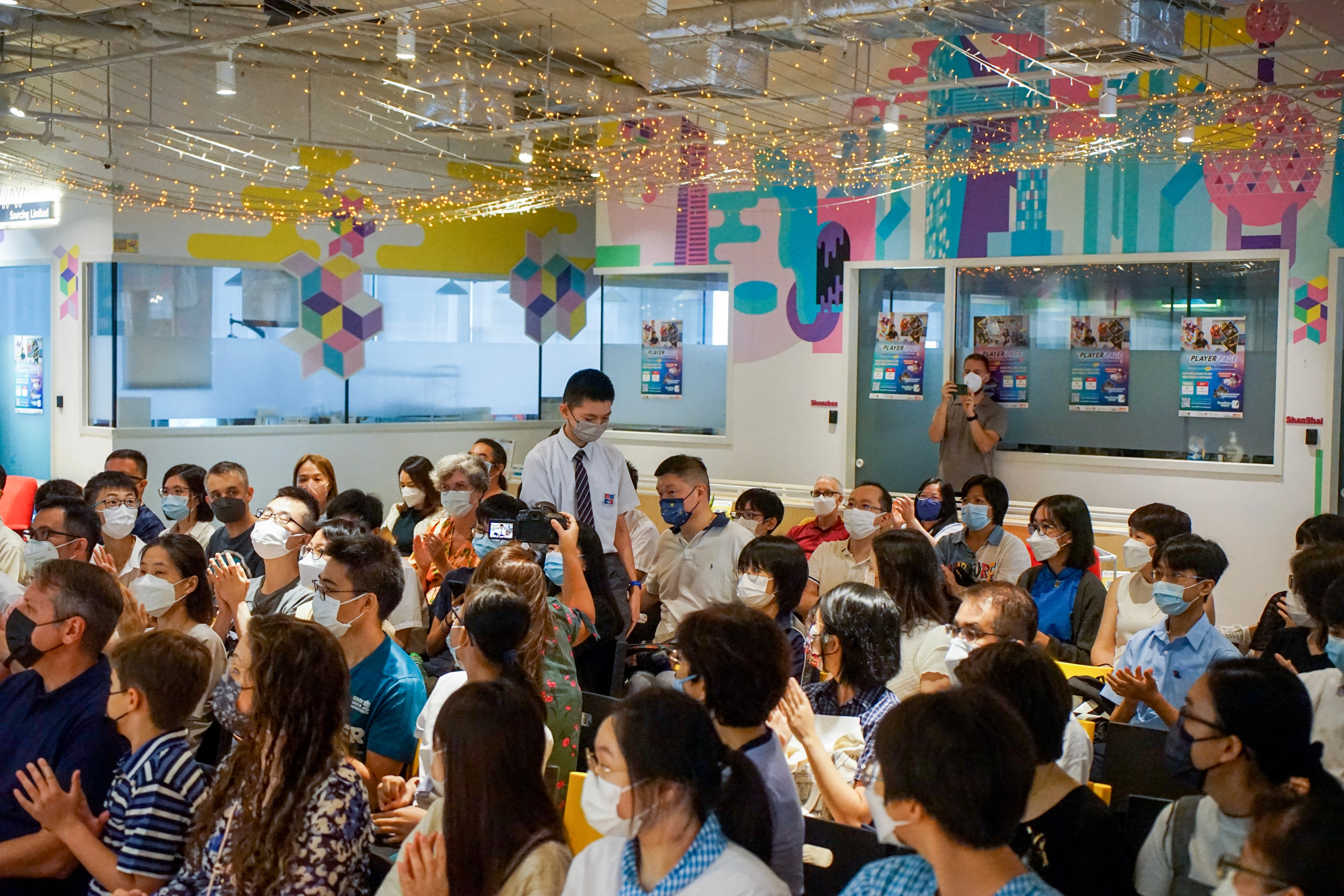 Crowded indoor event with attendees celebrating